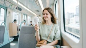 電車内でハンディファンを使っている女性